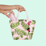 Girl's hand pulling a pink coffee tumbler out of a cute handbag with fern pattern and pink heart sunglasses hanging off the side..