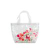 Cute clear handbag in vinyl with colorful pom poms in coral, pink, and seafoam.