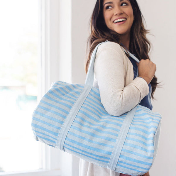 Cute duffel bag in canvas with light blue and blue stripes.