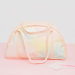 A pastel rainbow colored carry on bag with light peach straps and perimeter.