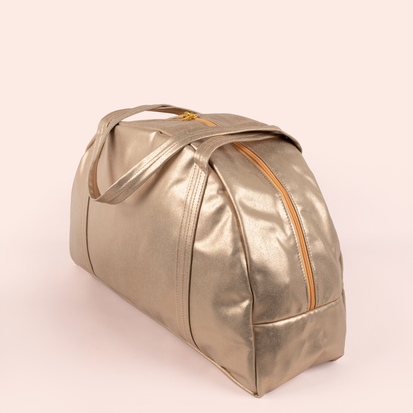 Angle view of a cute metallic gold large vegan leather zippered bag.