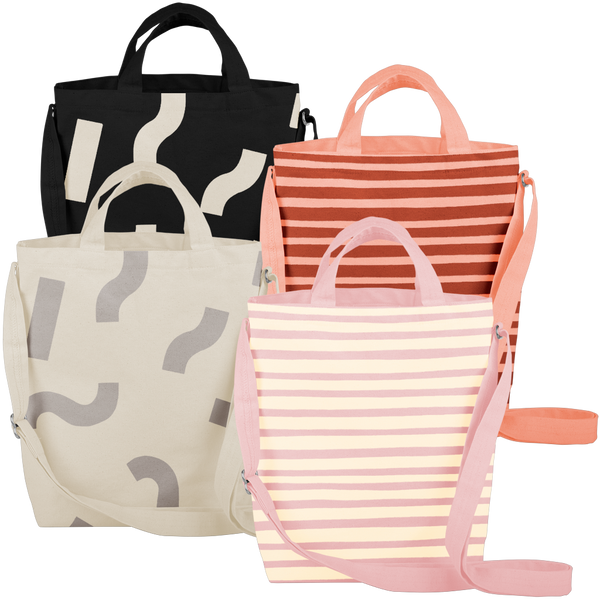 Four cute tote bags; pink with yellow stripes, light gray with gray macaroni, peach with red stripes, and black with white macaroni pattern.