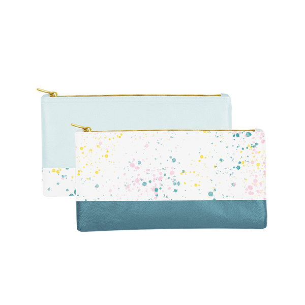 Two gold zippered, cute pencil pouches; one white with paint splatter print and a spruce green trim, one powder blue with white paint splatter trim.