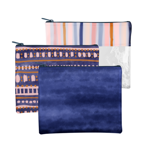 3 rectangle pouches. Top pouch is vinyl with a multicolored line design in pastels on the top of the pouch. The middle pouch is an indigo blue color with pink and tan abstract designs. Bottom pouch is a tie dye-like pouch in indigo blue.