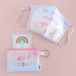 a pastel gradient pouch that says not today next to a matching mask that says im actually smiling