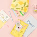 mix of cards, pens, notebooks, pins, desk accessories with a cute lemon print pouch