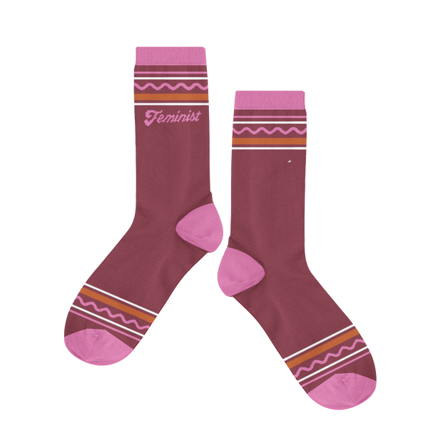 A jewel-toned purple sock with different line designed on the ankle and toe of the sock. "Feminist" is printed under line design.