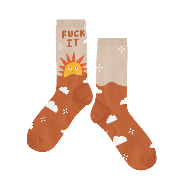 Long socks with a sun rise and the phrase "Fuck it" displayed are the top of the sock. Lower part of the sock is brown with clouds and sparkle stars.