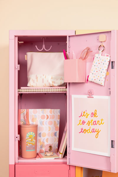Pale pink pouch inside a pink locker with other items.