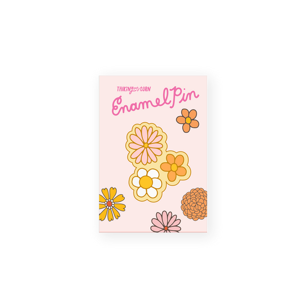 enamel pin of three daisy flowers in pink, white and orange