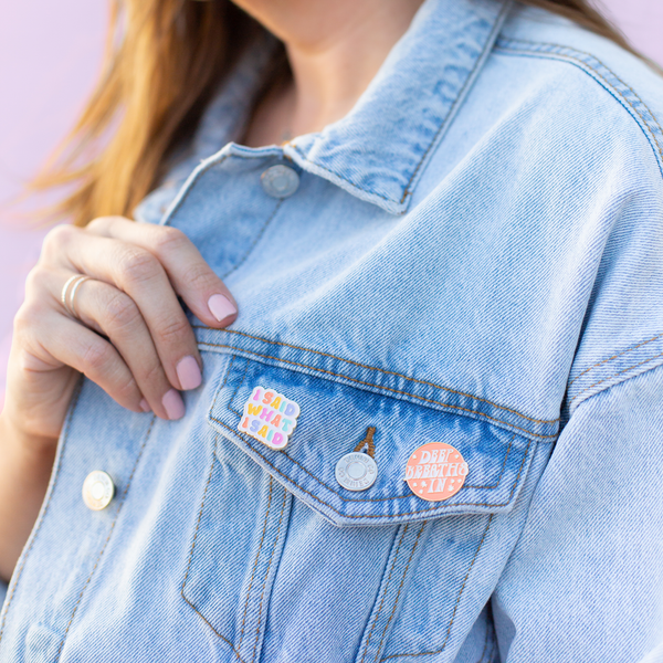girl in denim jacket with pins saying "I said what I said" and "deep breaths in"