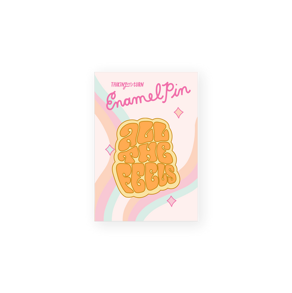 enamel pin saying all the feels in groovy font orange on yellow background