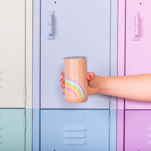 A hand holding out the "emotional rollercoaster" tumbler in front of pastel colored lockers.