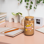 A 16 oz can glass with glass straw. "ZERO FUCKS GIVEN" is printed on the front in multi-color font; illustrations of a cloud, rainbow, and sun surround the text.