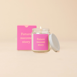 A 8 oz. candle jar with lid, with a pink decal on it "Future success story" printed on.