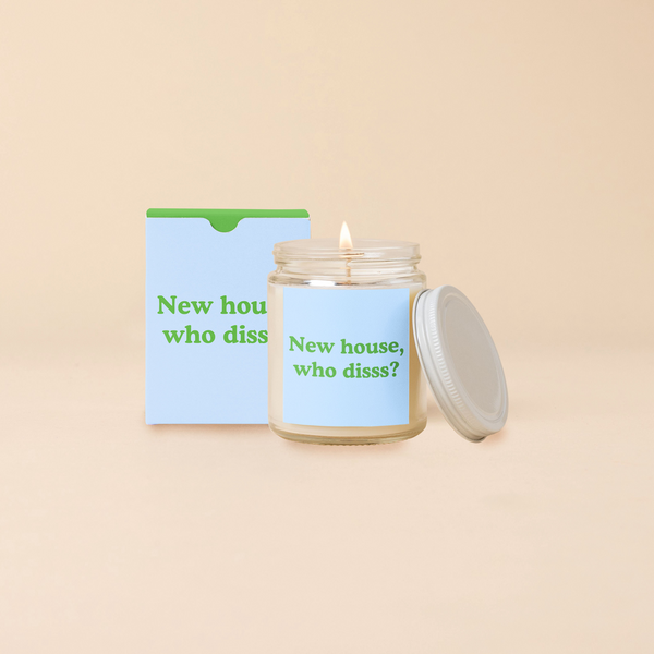 A 8 oz. candle jar with lid, with a light blue decal on it "New house, who disss" printed on.