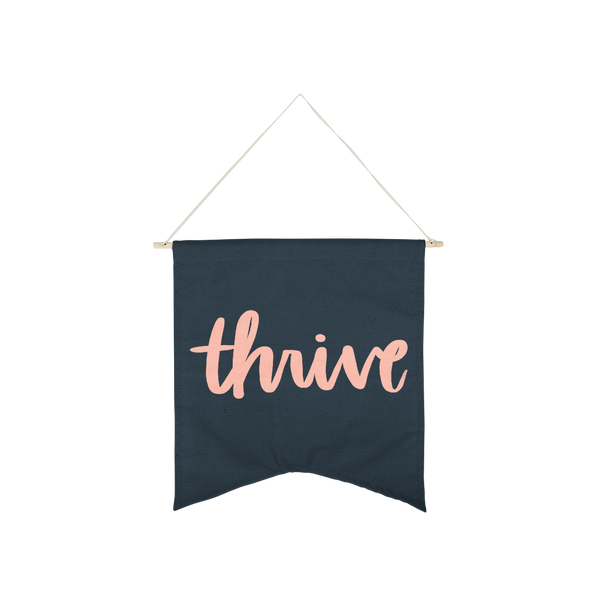 Thrive Wallflower is a cute canvas wall hanging in navy blue with pink lettering.