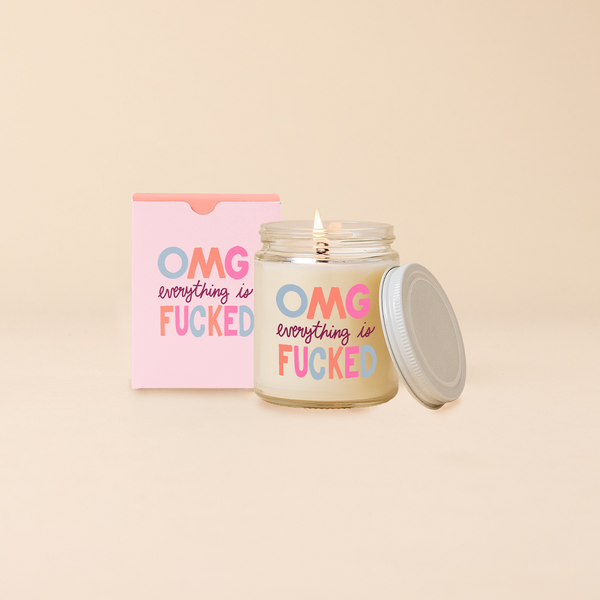 A jar with lid candle with multi color text saying "OMG everything is FUCKED" in the scent tickled pink Citrus + Floral 