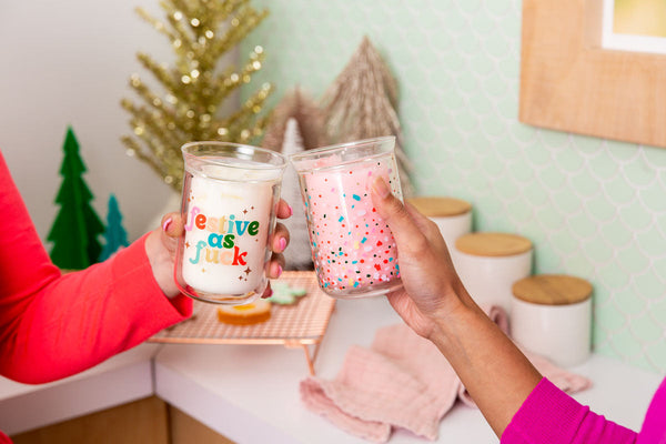 Clear candle with "festive as fuck" on text. Pink candle with confetti multicolored. 
