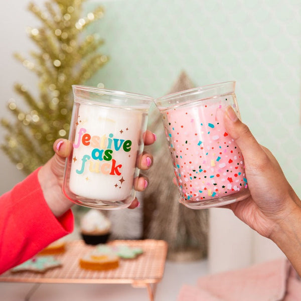 Clear candle with "festive as fuck" on text. Pink candle with confetti.