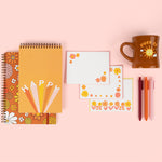 cute set of notebooks one with flowers, one saying happy with a set of letterpress notecards with flowers, set of pens and a brown diner mug with the saying fuck it with sunshine