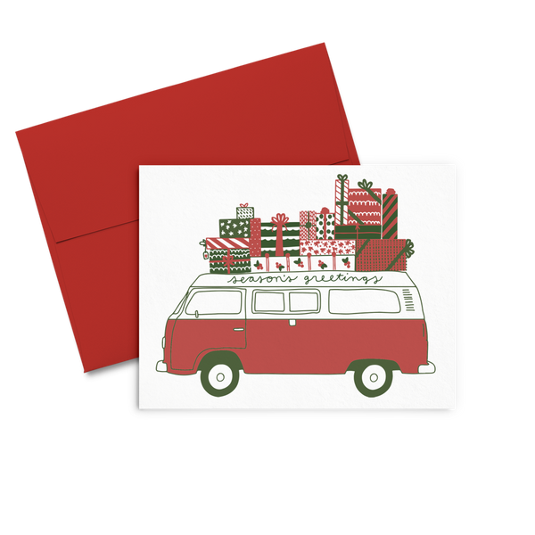 greeting card with a red and white van the top covered in christmas present, 'seasons greetings' written on the top. 