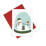 a greeting card with two snow men in a snow glob holding hands with a christmas tree between them.