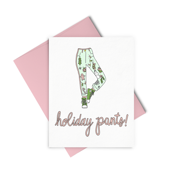 a greeting card in pink cursive saying 'holiday pants!' a drawing of green pants with ginger bread, snowmen, trees, lights and holly.
