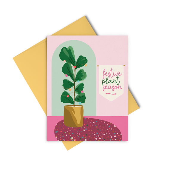 A pink and green greeting card that says "festive plant season" and has an illustration of a houseplant with colorful ornaments.