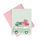 Light green snowy card with a green "seasons greetings" van with colorful presents on top of it
