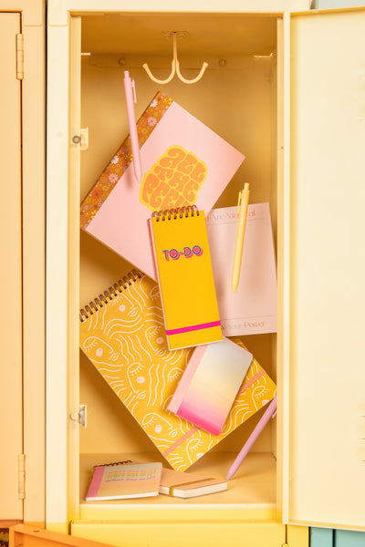variation of yellow notebooks and taskpads inside a yellow locker