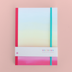 A rainbow ombre notebook with a hot pink spine.