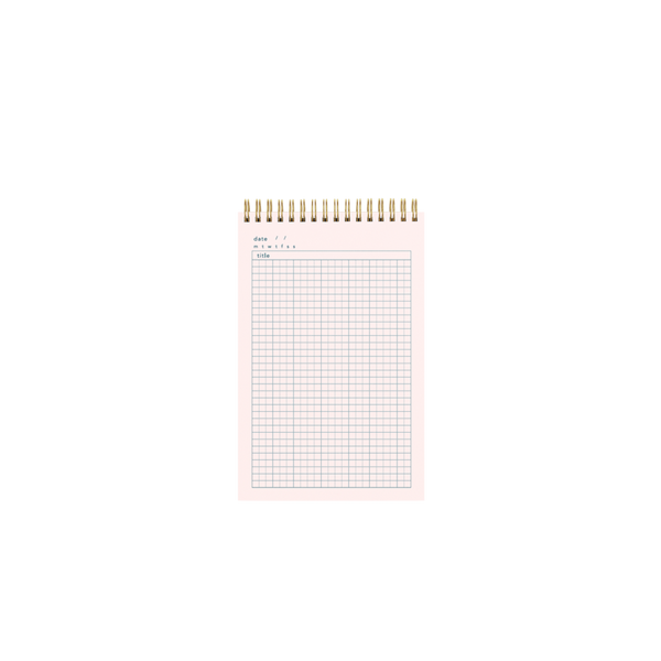 Inside pink page of a gold wire-bound taskpad showing a grid paper design.