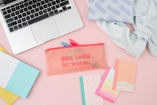 a ripstop pouch that says shit could be worse next to a macbook