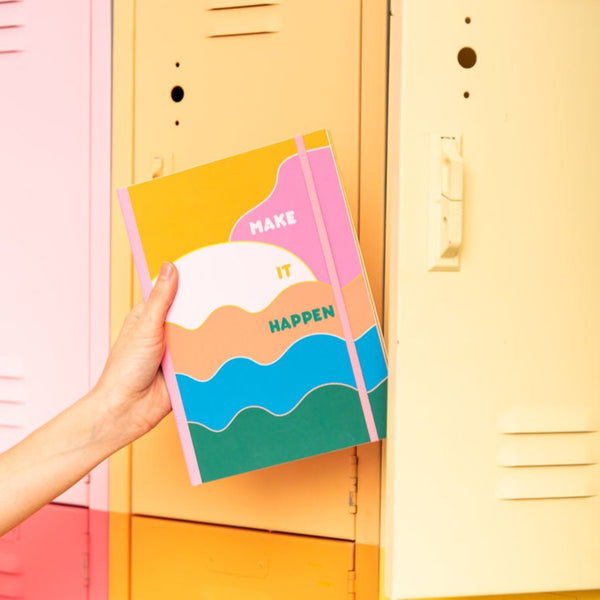 a hand putting a planner with the phrase 'make it happen' three waves in green, blue and orange on it, the sky in two shades of yellow and pink, and a yellow sun. 
