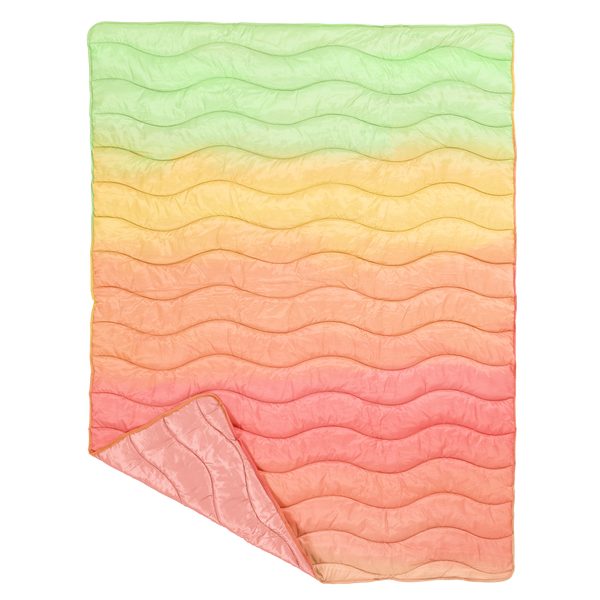 puffy quilted blanket in a colorful gradient pattern with a solid pink on the backside