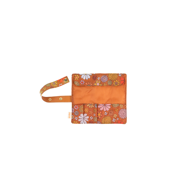 Small TOOTsie roll pouch open with brown background and groovy floral patterned pockets