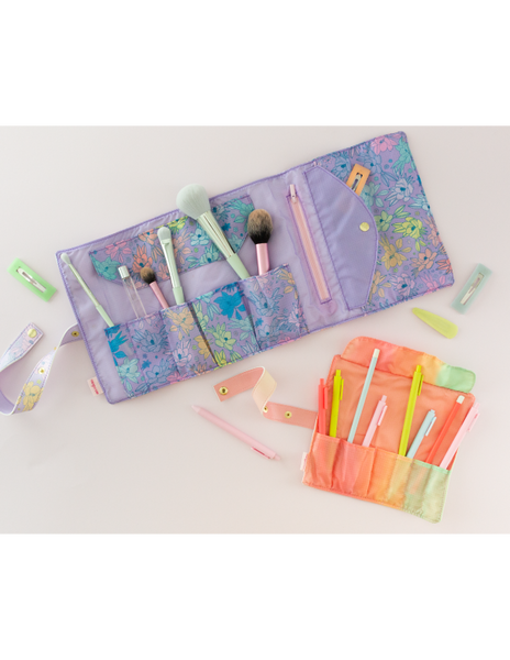 Large and small TOOTsie roll travel pouches open with fun prints and colors filled with makeup brushes and jotter pens