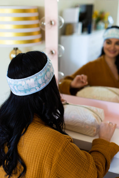 Mint and White abstract moon designed spa head wrap displayed on a person doing their makeup.