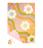 Picnic pal that comes in a small bad and with an ombre background, with white daisies, and a groovy wave pattern in the color of green, purple, and orange. 