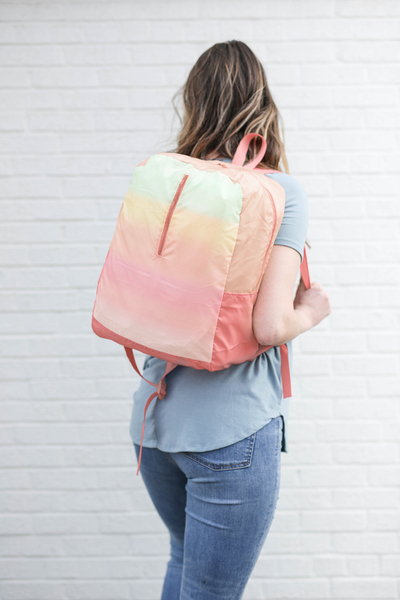 a girl wearing a ripstop backpack with a pastel gradient print.