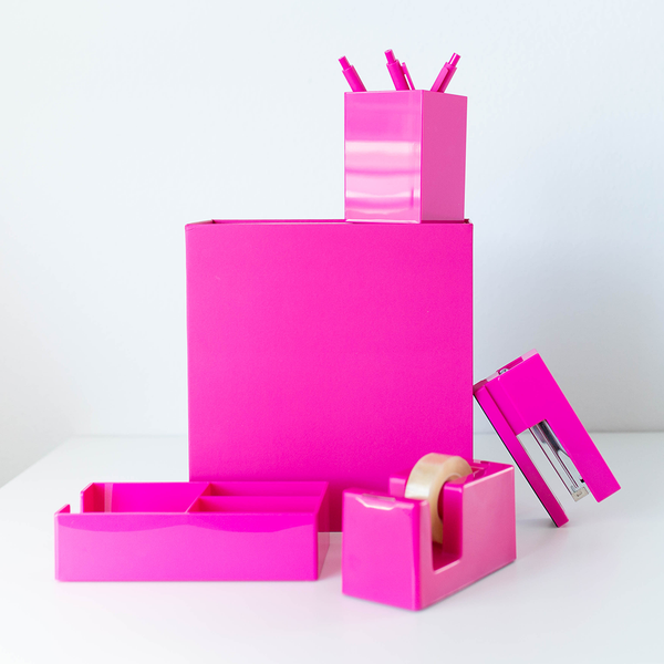 A pink desk set stacked around a pink gift box. 
