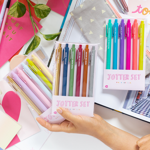 A multicolored pastel Jotter set, a darker colored Jotter set, and a multicolored, bright Jotter set. All three sets are on a desk display with other stationary items displayed as well.