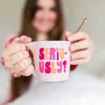 Girl holding a light pink element mug with "seriously" on it in shades of pink and peach.