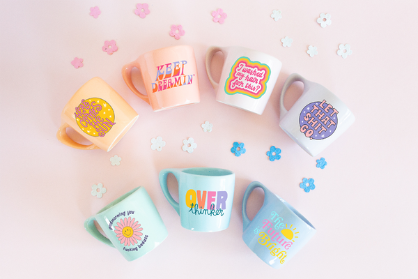 collection of coffee mugs with funny sayings with flower confetti