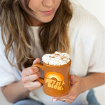 Lady holding brown diner mug with "Dont be a dick" written on it with whipped cream and cinnamon on top.