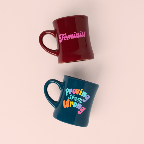 two old school diner mugs- one sangria with feminist in pink and a navy one with colorful letters saying proving them wrong?id=28703084740789