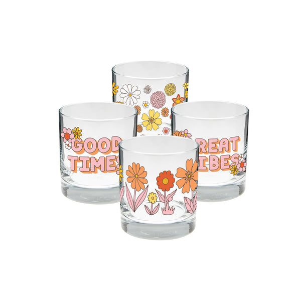 A set of 4 glass cups. One with the phrase "Good Times" printed on with flowers and both ends of the phrase, another with different flowers printed in one line around the cup, one cup with "Great TImes" printed on with flowers at both ends, and one glass with different flower heads printed all over. Colors of flowers and wording on each much are orange, pink, yellow, and white.