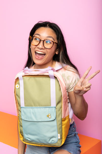 Happy girl wearing the multi color everyday backpack. 