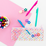 A clear pixie pouch with mini multicolored hearts all over. Kit includes three Jotters in Bright Blue, Pink, and Teal. Displayed on white surface with plastic flowers and other Jotter Pens.